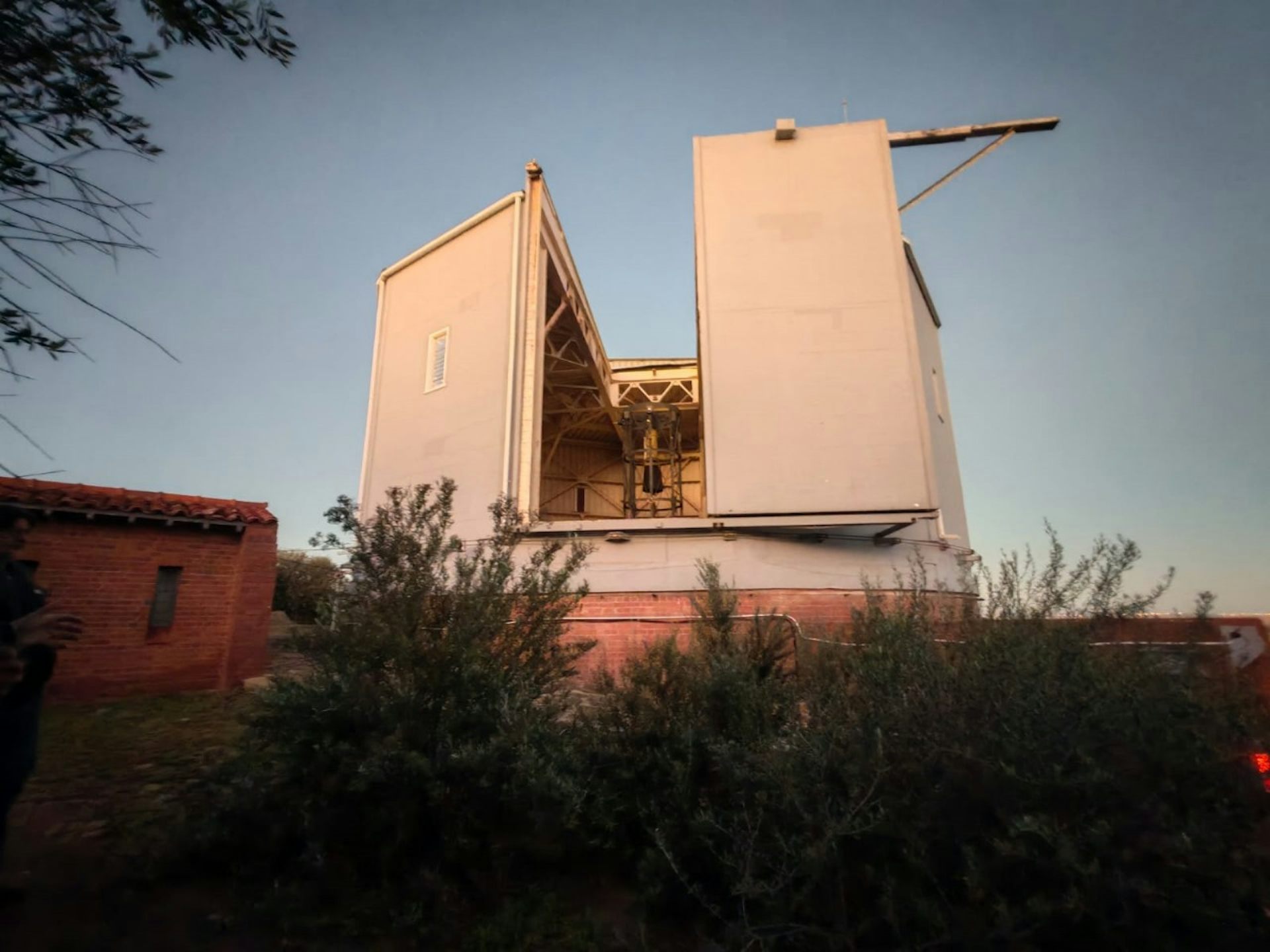 A square shaped two storey building in an outdoor bushy area