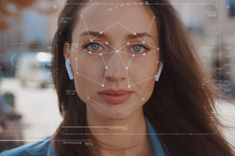 Close up of woman's face as she walks along street wearing earbuds, diagram covering her face