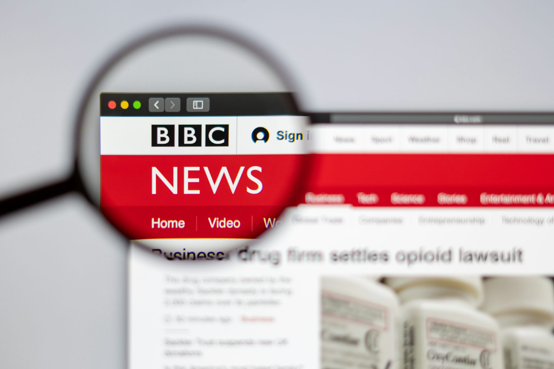 A magnifying glass over the BBC News logo on its website