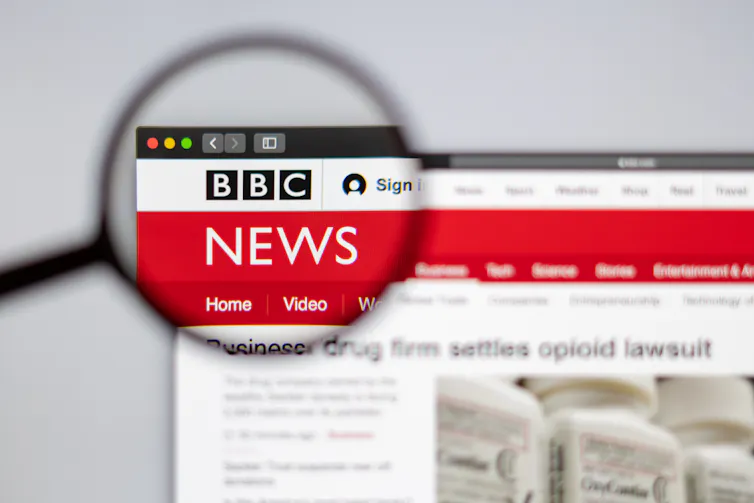 A magnifying glass over the BBC News logo on its website