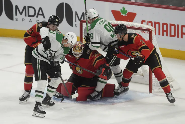Los jugadores de hockey luchan por el disco sobre el hielo durante el juego.
