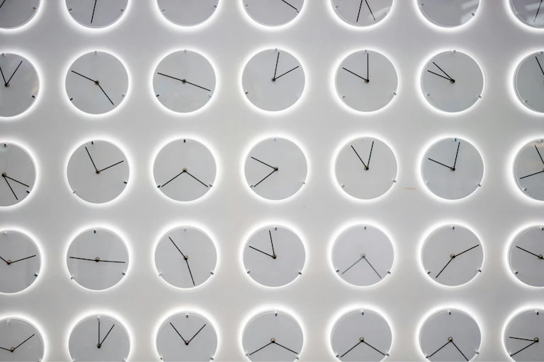 rows of monochromatic gray clocks showing different times