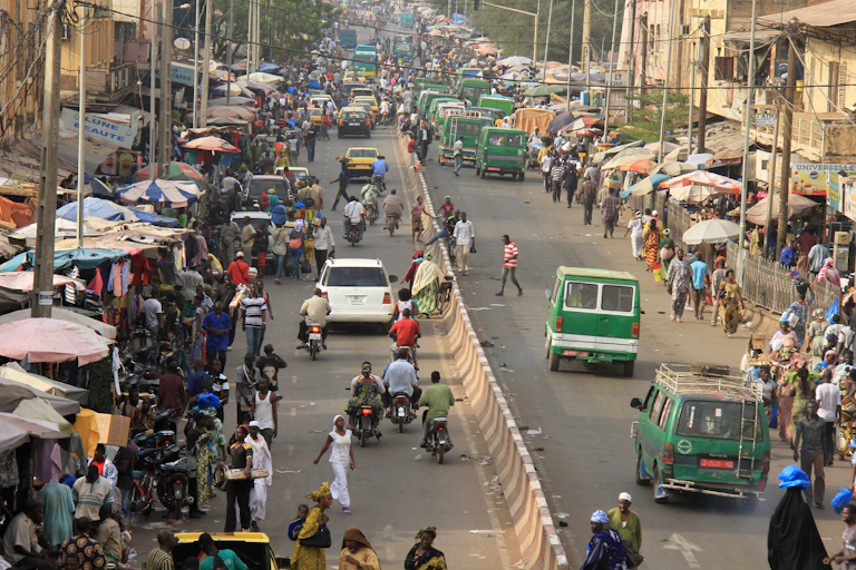 People and cars move along a busy roadway