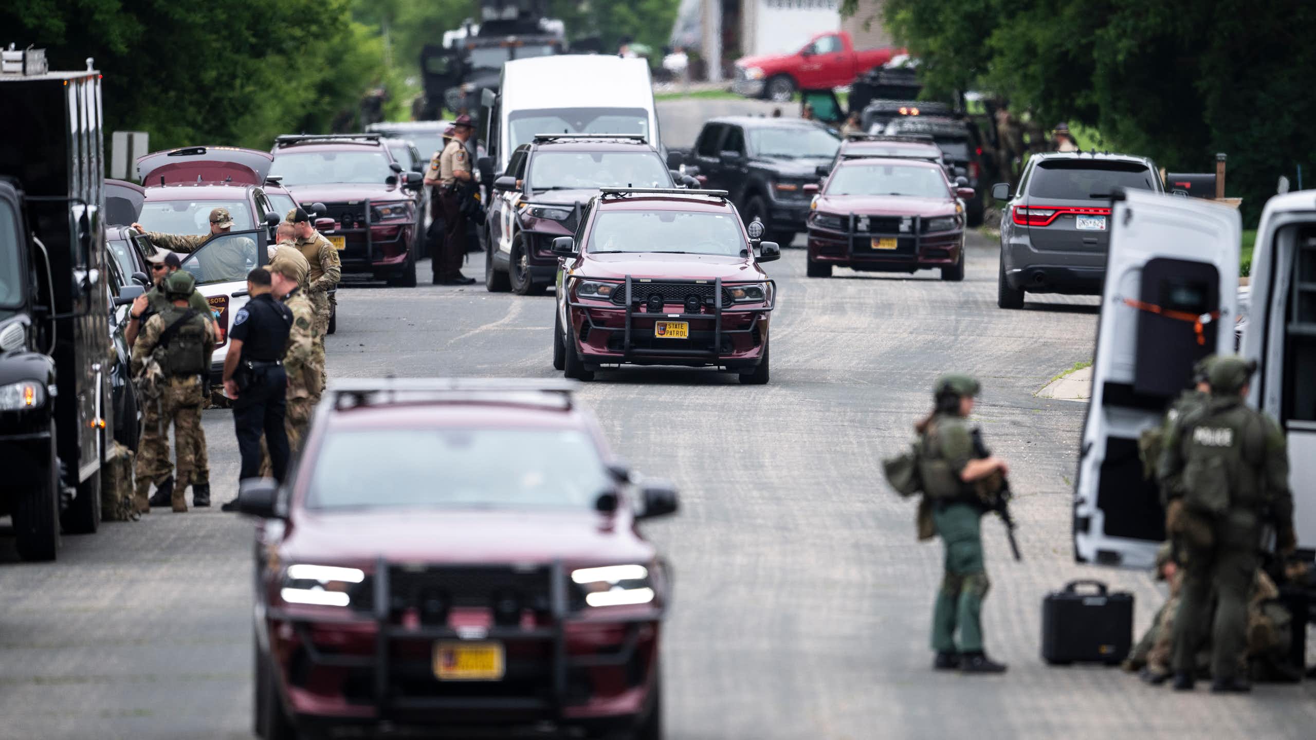 Police vehicles and other cars on a street.