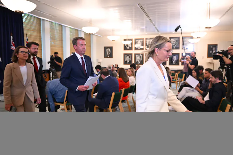 Opposition leader Sussan Ley and members of her ministry walk past media after a press conference.