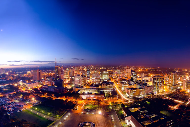 Several well-lit buildings against a dark blue sky.