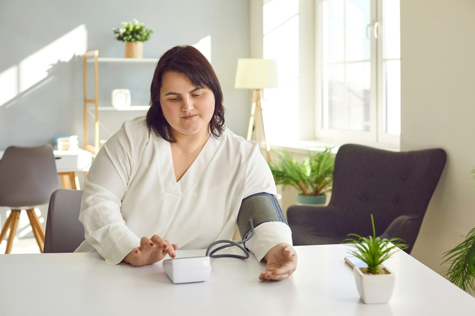 A woman taking her blood pressure at home.