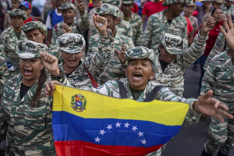 Members of Venezuela's Bolivarian militia hold a Venezuelan flag.