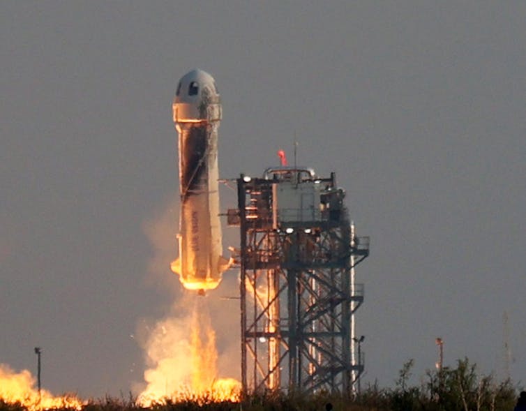 A short, wide rocket lifts off from a launchpad.