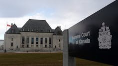Un edificio con columnas blancas detrás de un cartel que dice Corte Suprema de Canadá.