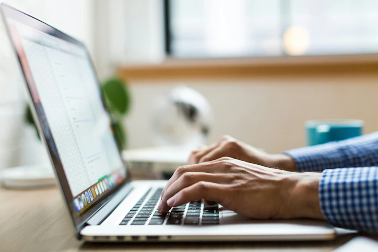 Close up of hands typing on a laptop