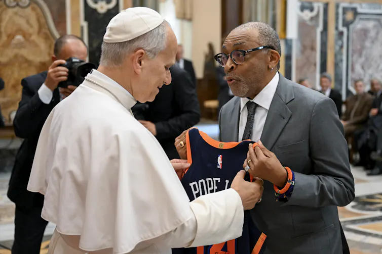 American filmmaker Spike Lee presents the pope with a custom-made Knicks basketball jersey inside the Apostolic Palace, Vatican City.