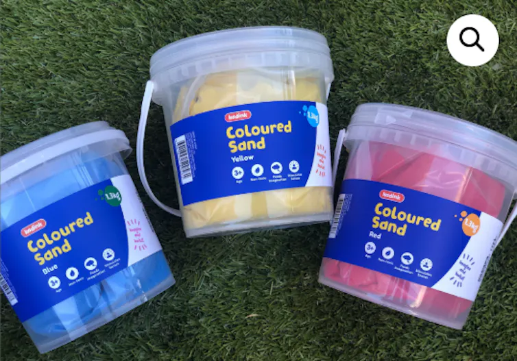 A blue, yellow and red tub of coloured sand.