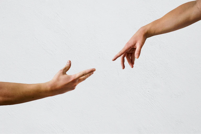Two hands reaching out towards each other