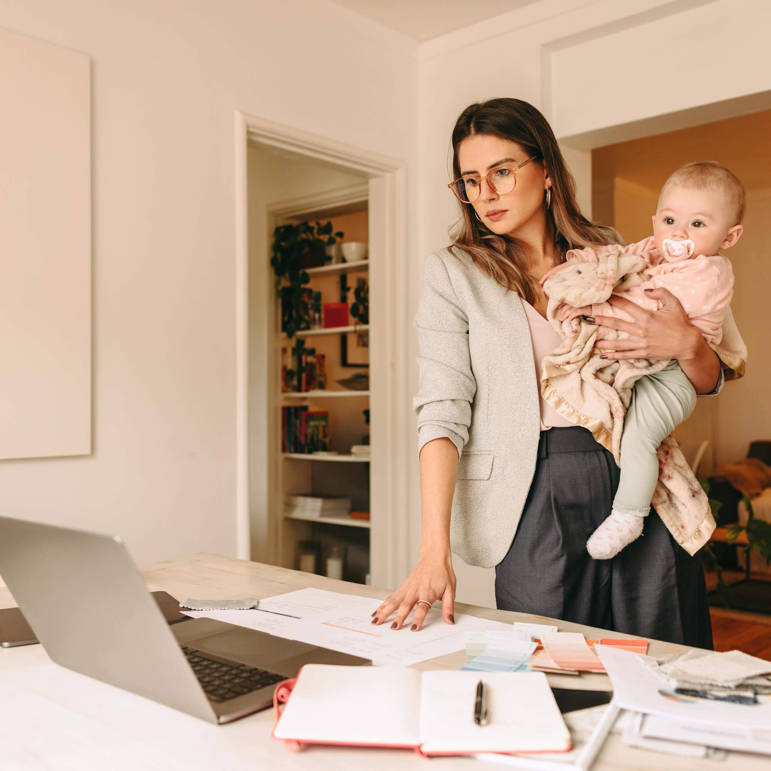 Una mujer trabajadora sostiene a su bebé.