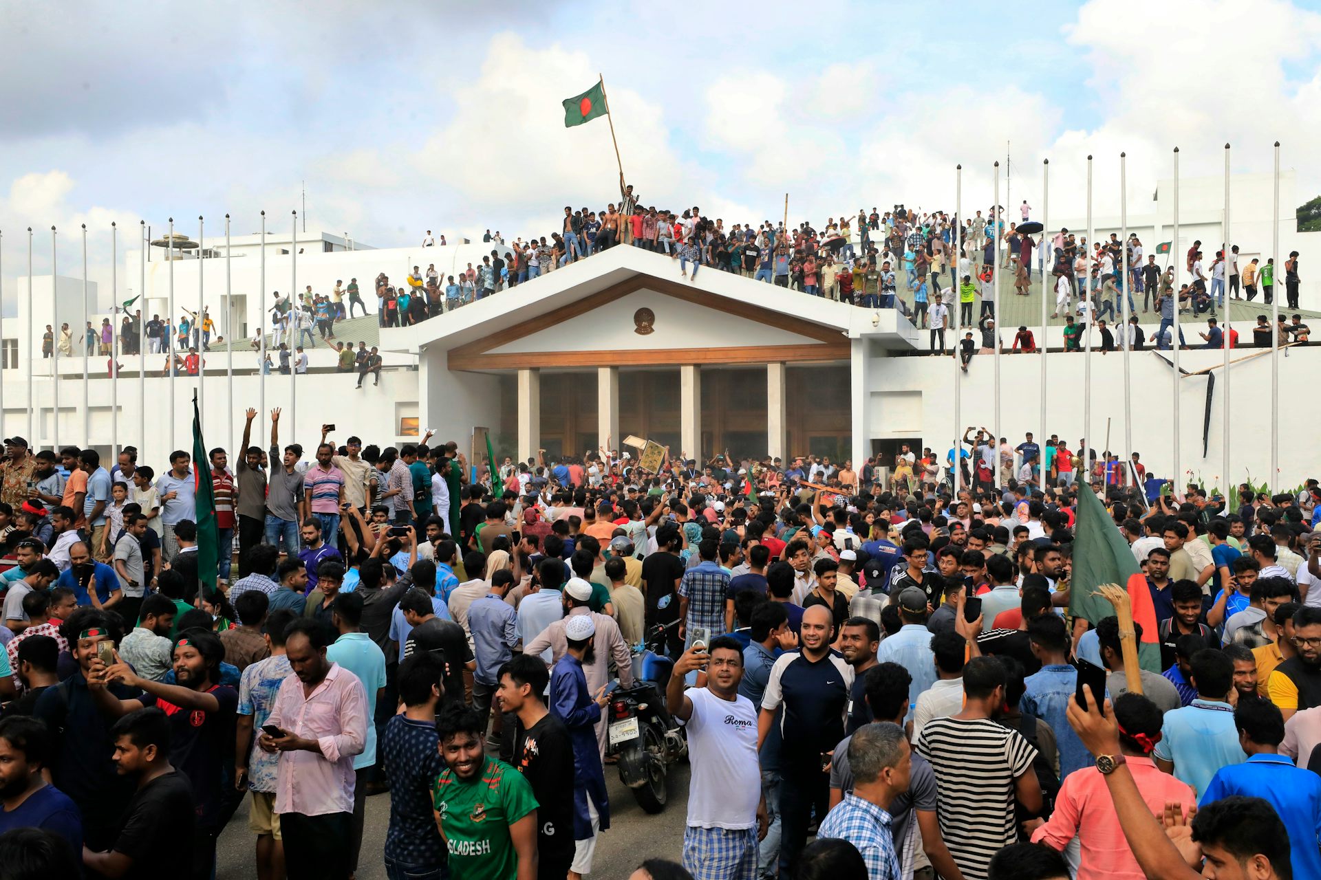 Protesters outside and on the roof of an official building.