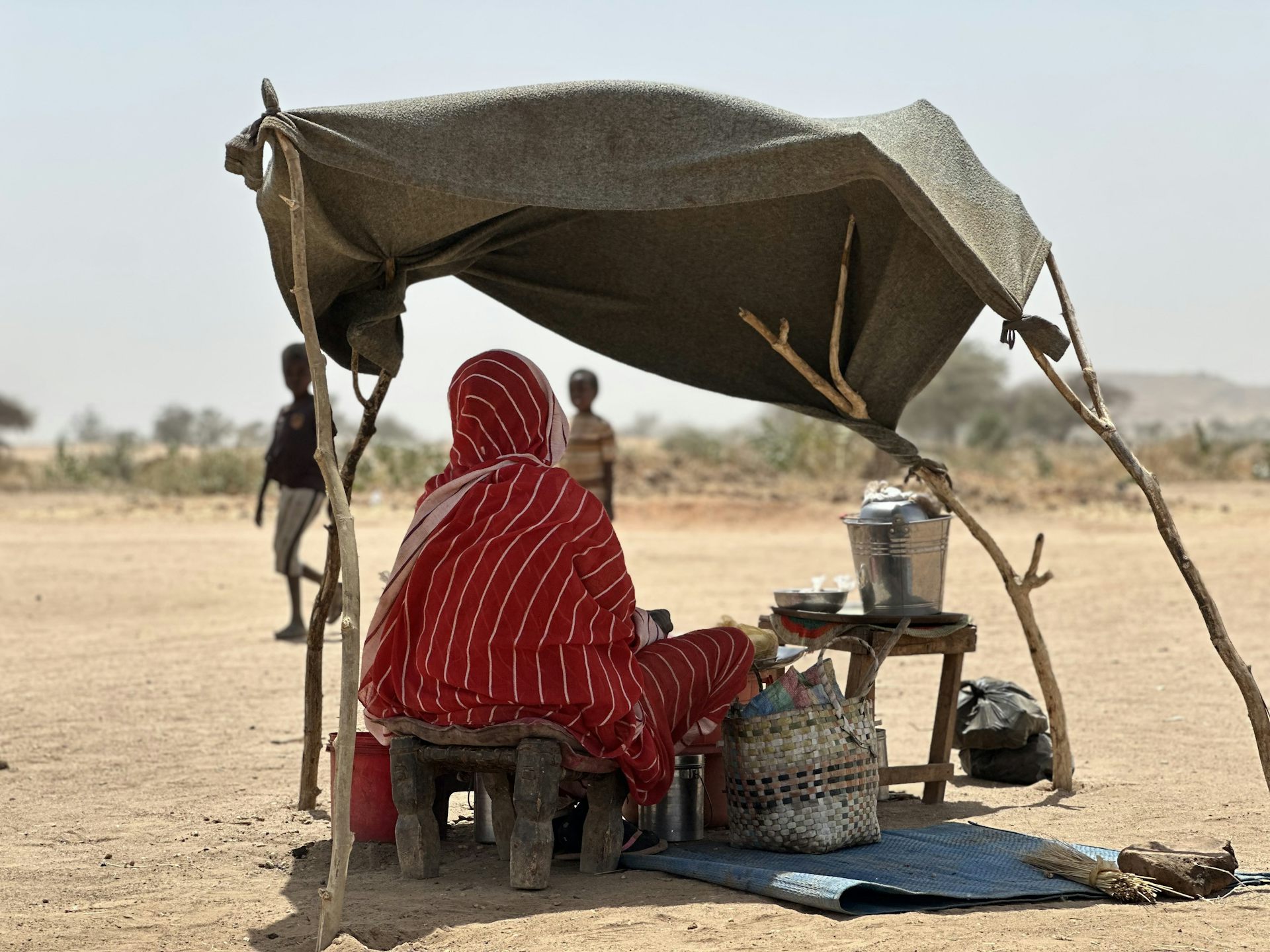 A person gets some shade in a makeshift shelter.