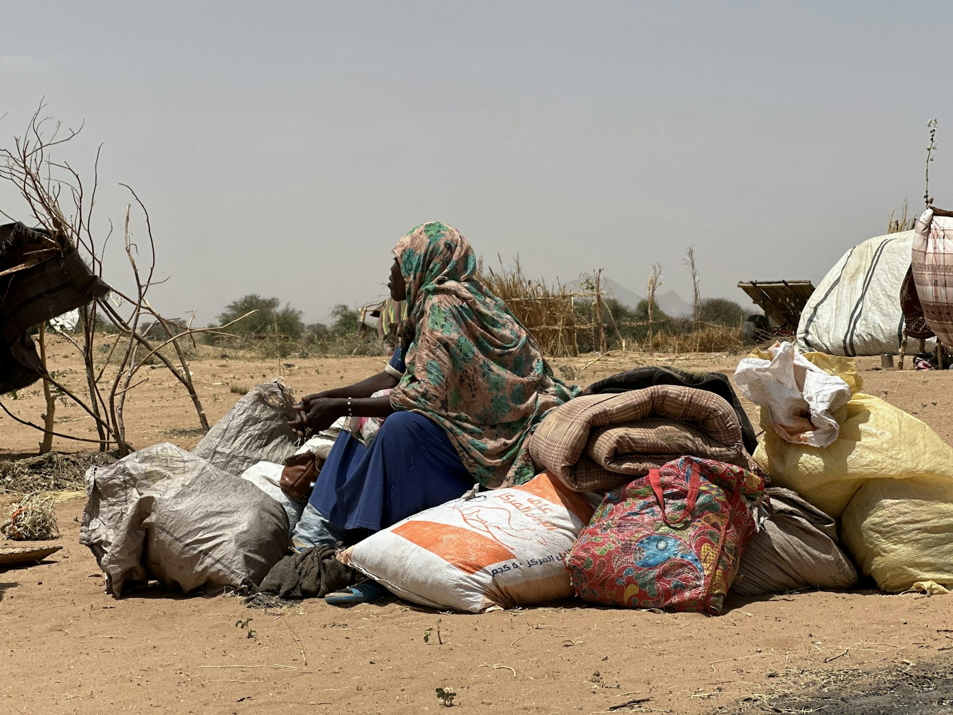 A woman sits on a pile of sacks