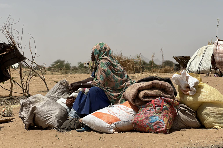 A woman sits on a pile of sacks