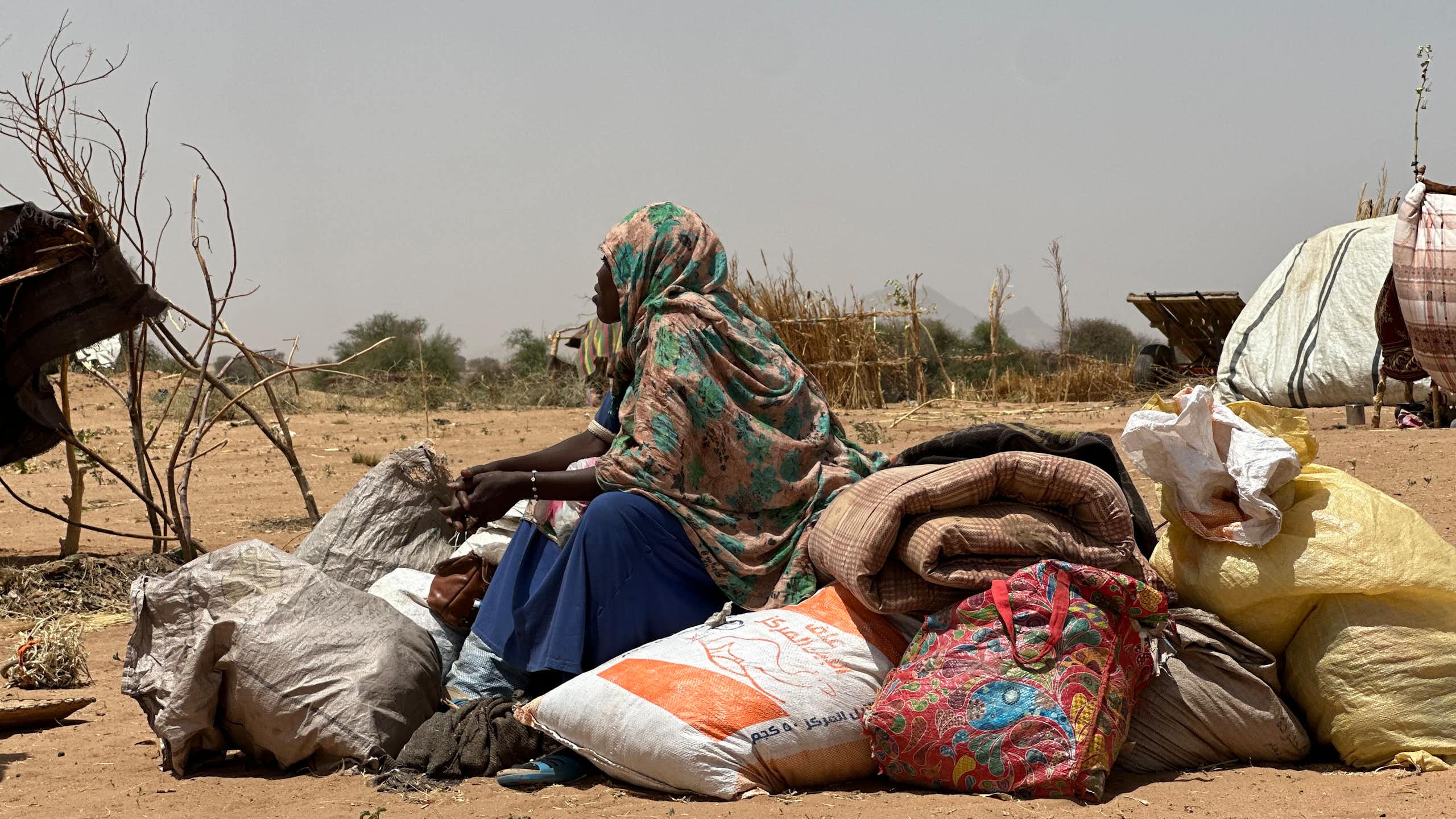 A woman sits on a pile of sacks