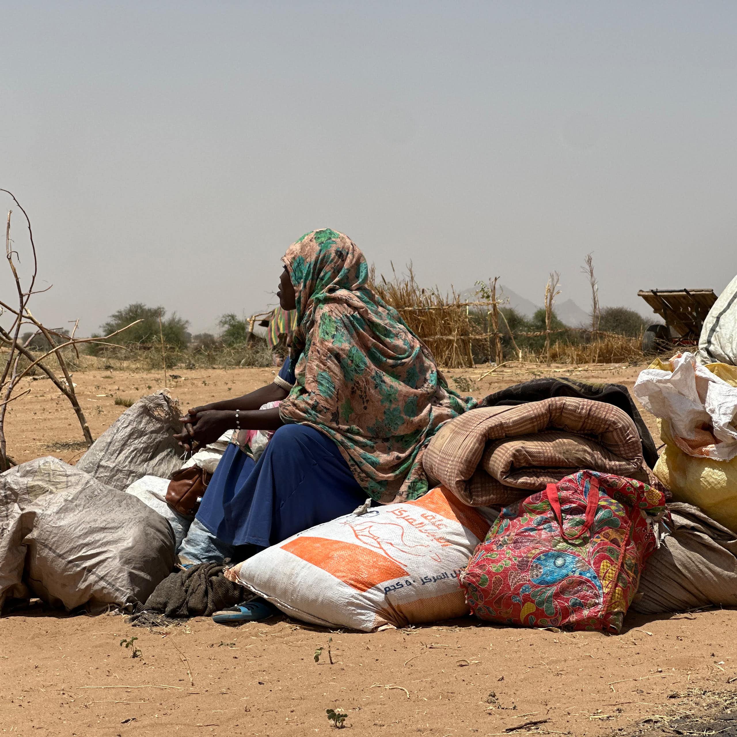 A woman sits on a pile of sacks