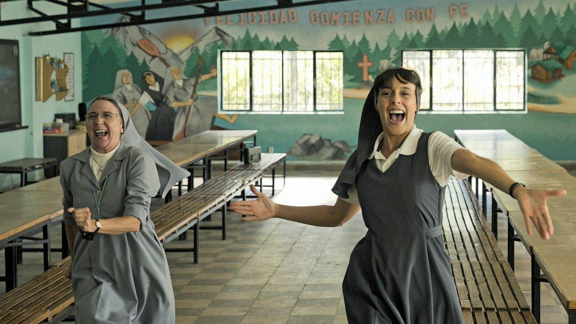 Dos monjas bailan en un comedor vacío.