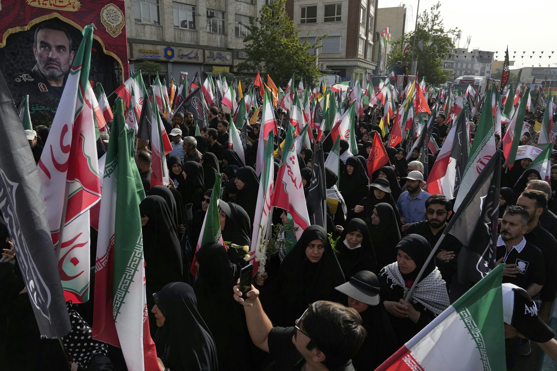 Des personnes portent des drapeaux iraniens