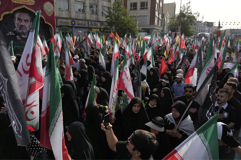 Des personnes portent des drapeaux iraniens