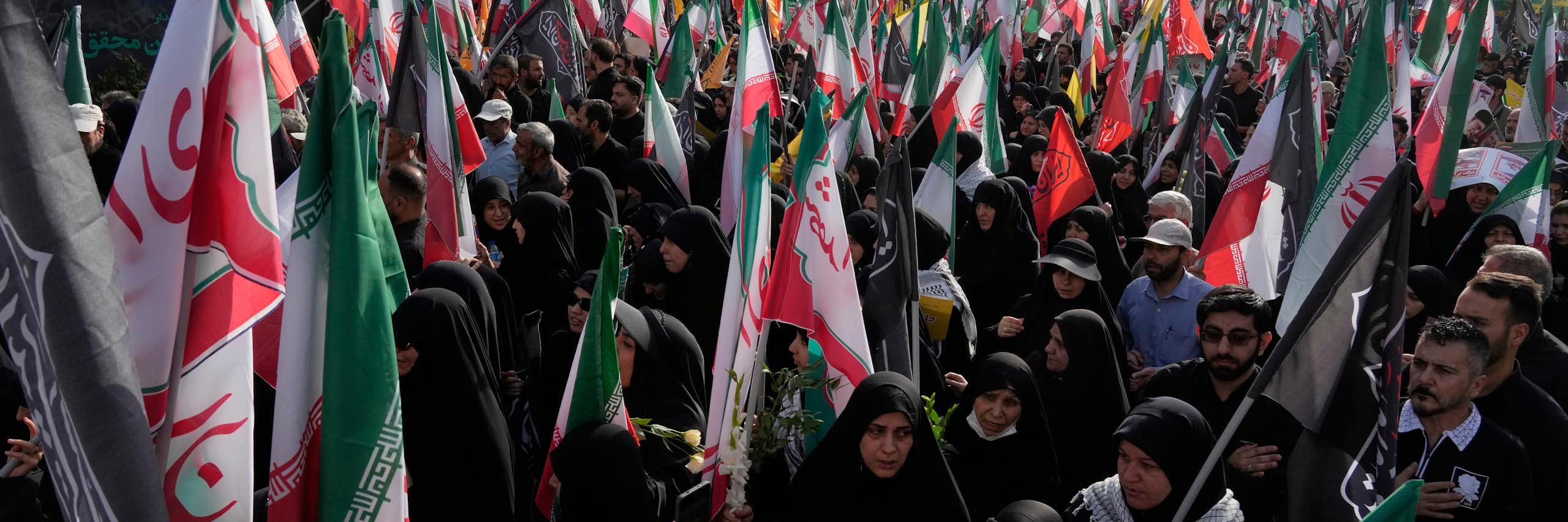 Des personnes portent des drapeaux iraniens