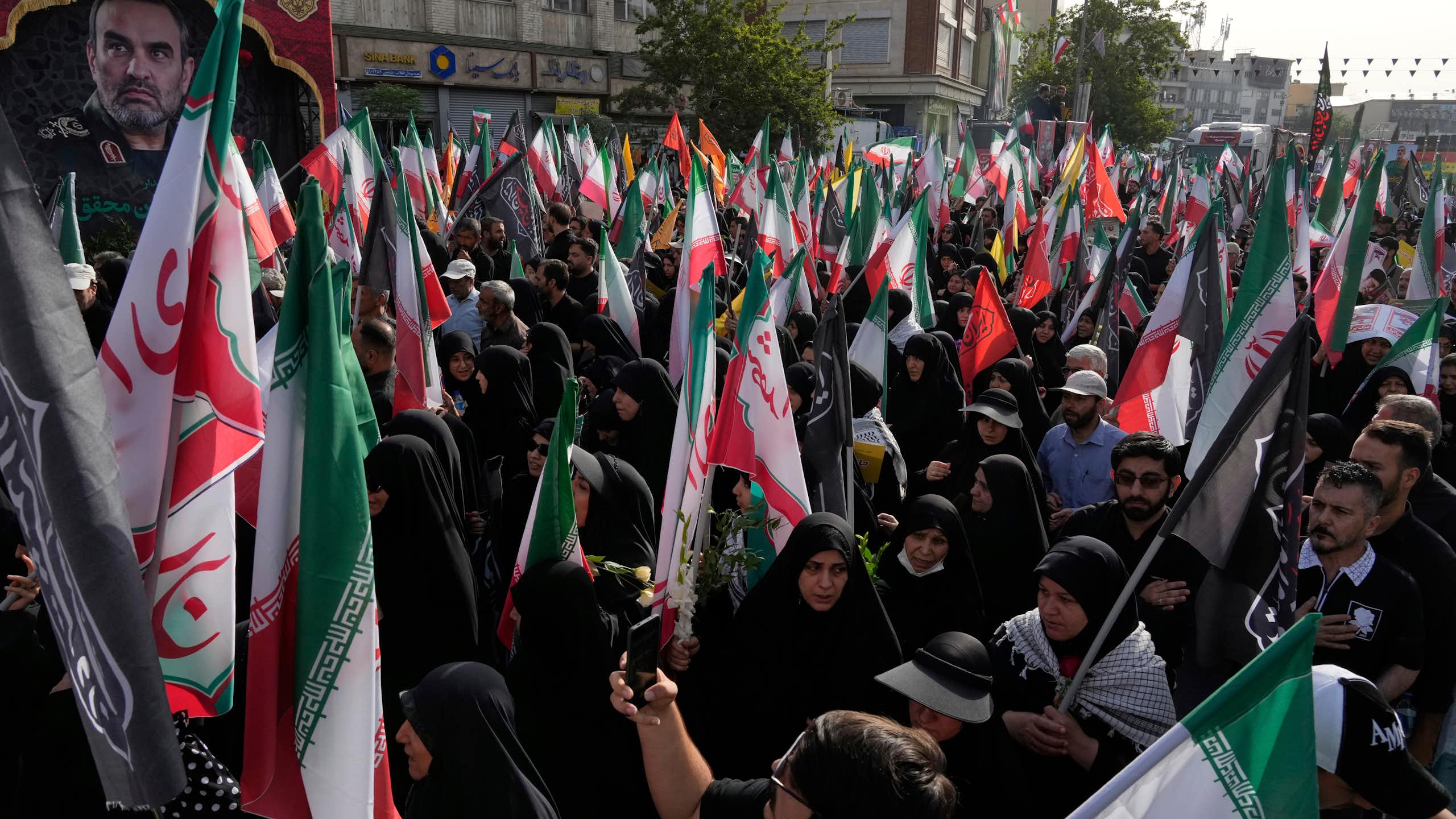 Des personnes portent des drapeaux iraniens