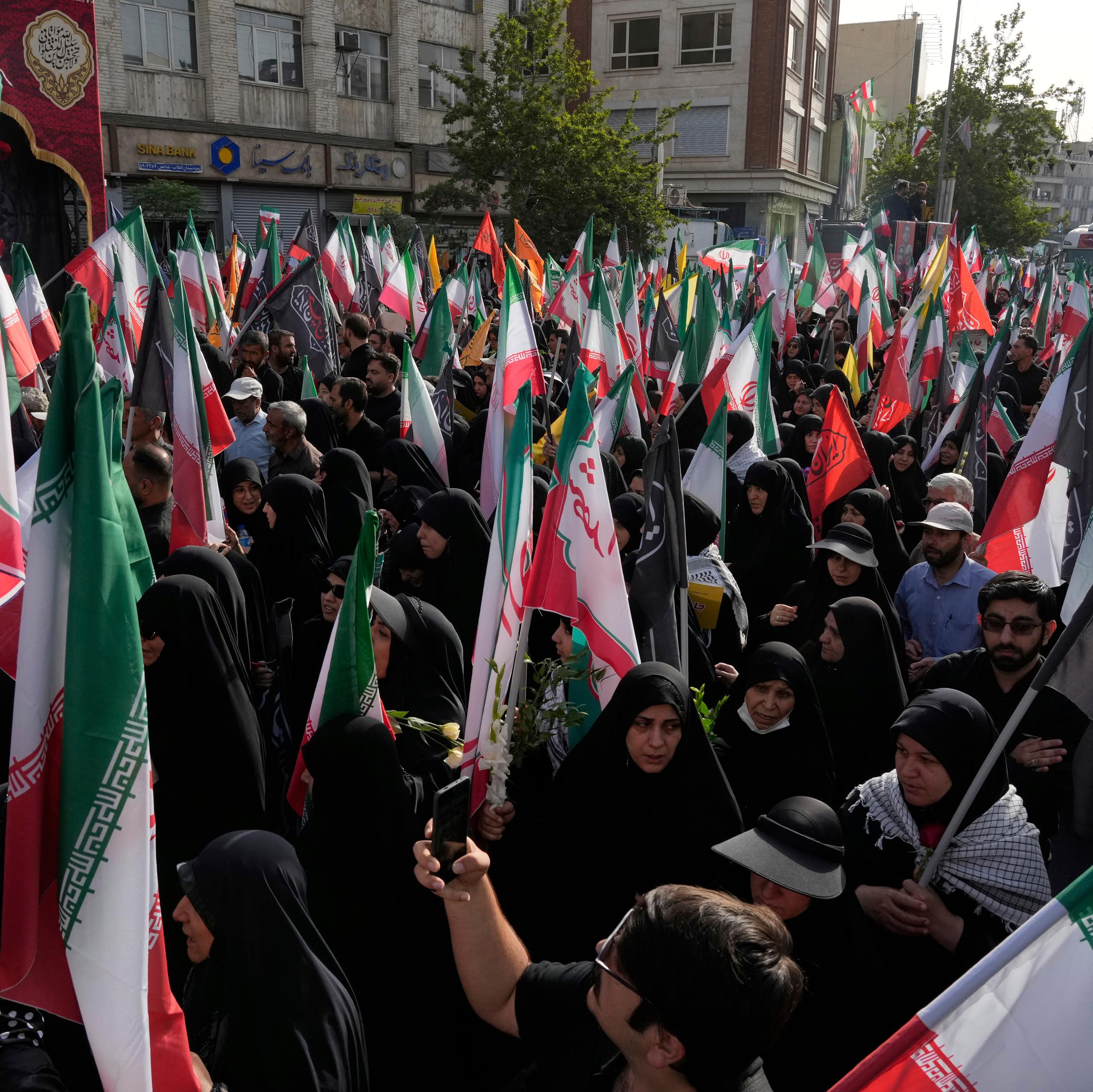 Des personnes portent des drapeaux iraniens