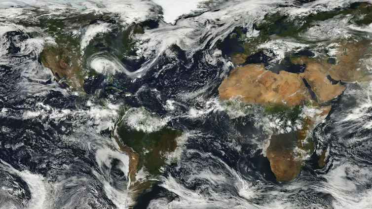 The Earth's continents and oceans with dappled clouds.