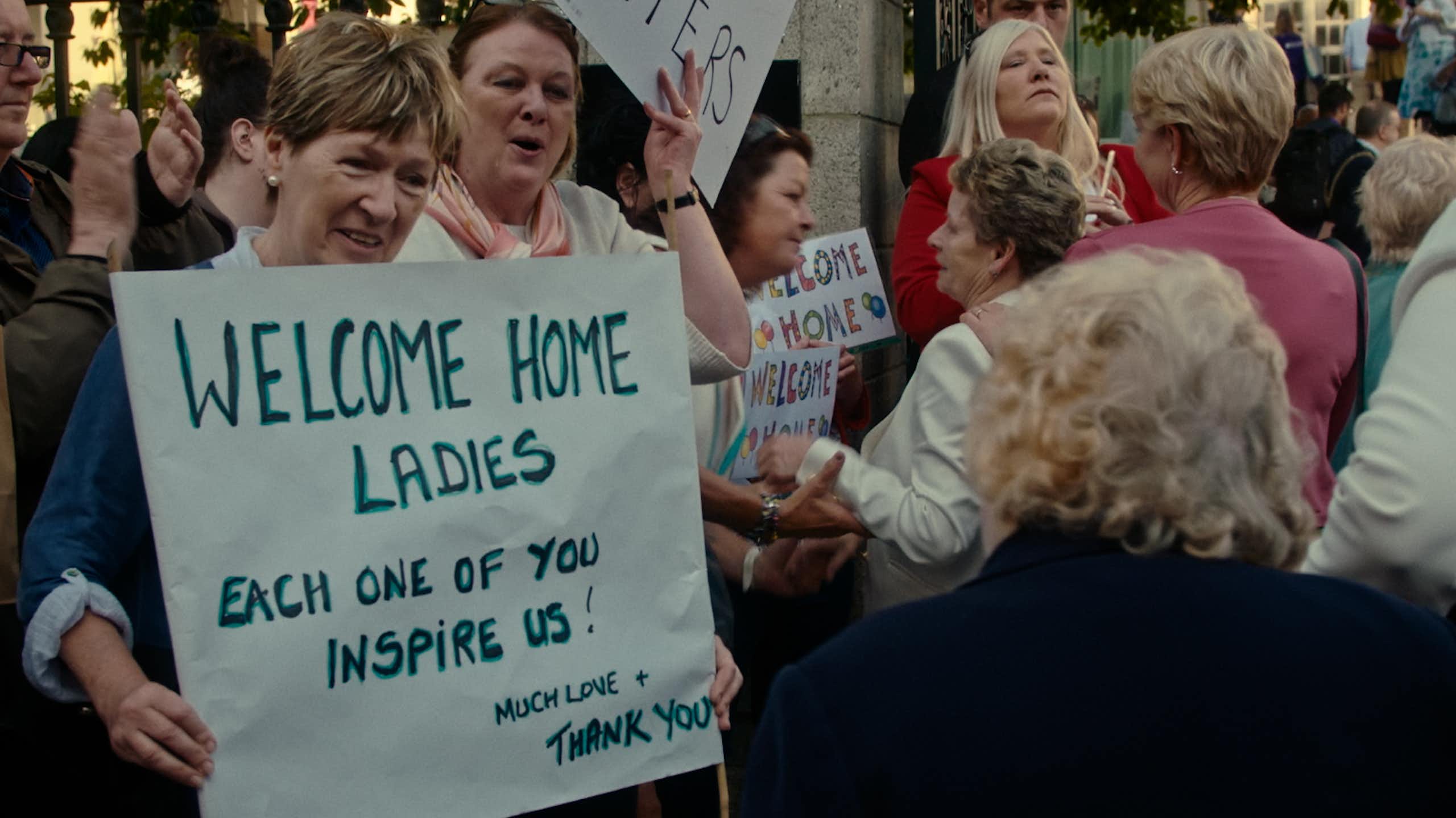 People holding up welcome signs