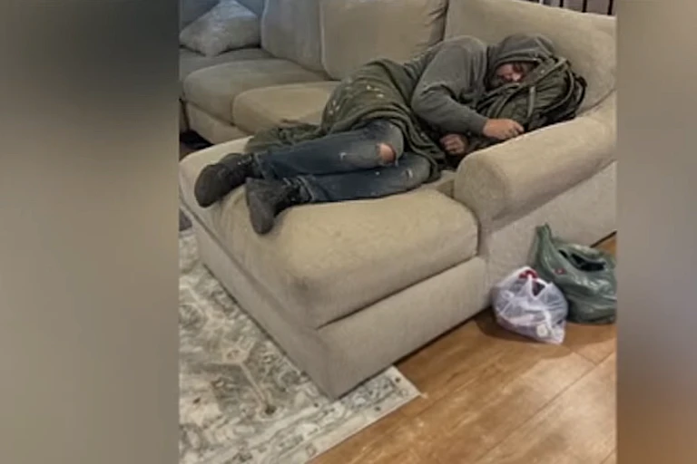 Image générée par l'IA d'un sans-abris dormant dans le salon d'une maison.