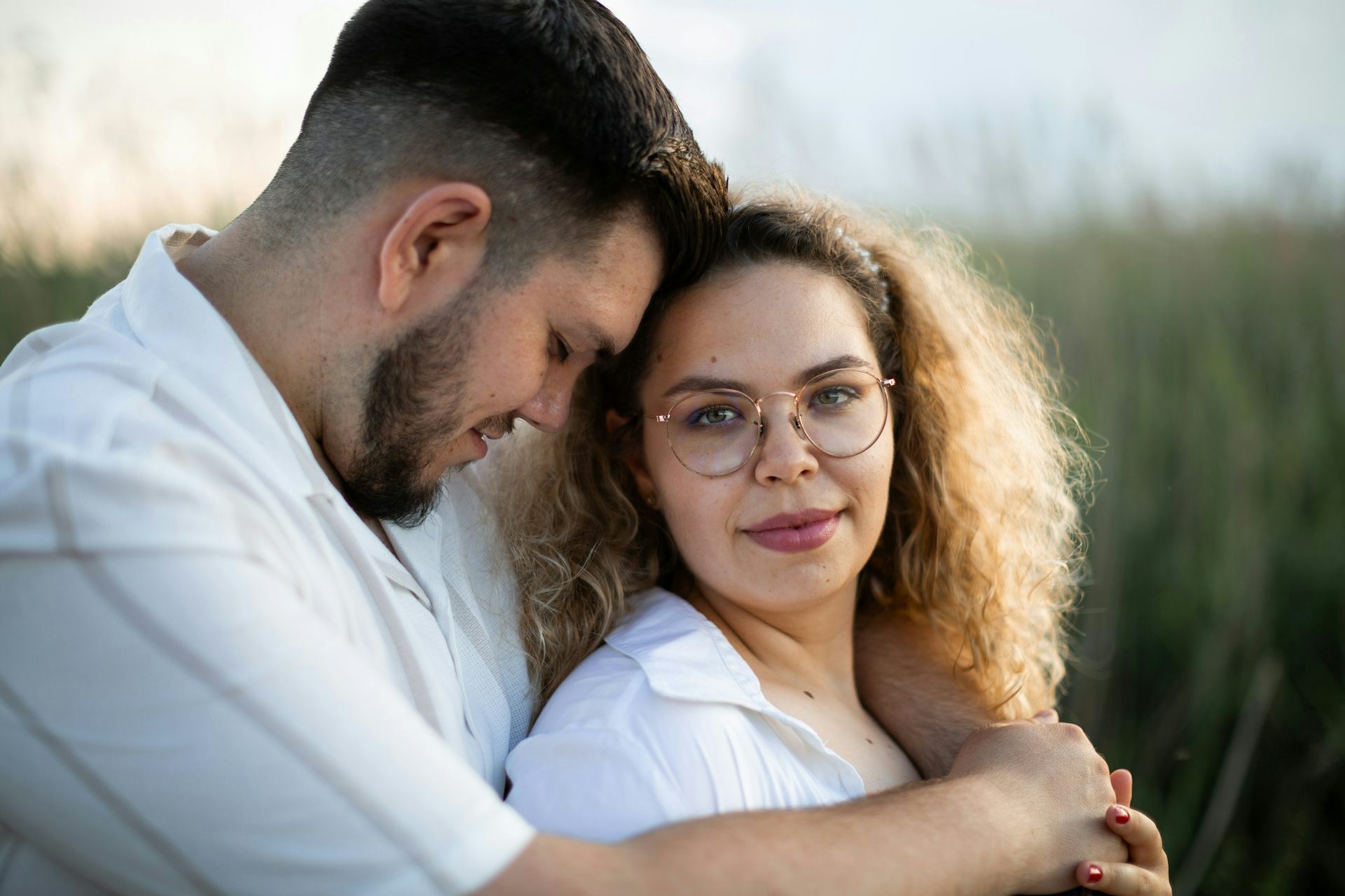 A couple hugging in and outdoors scene.