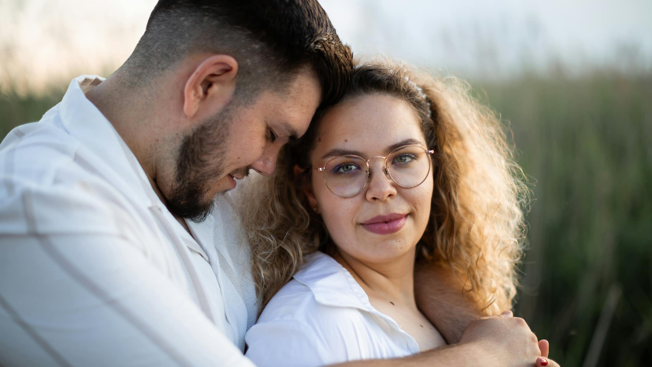 A couple hugging in and outdoors scene.