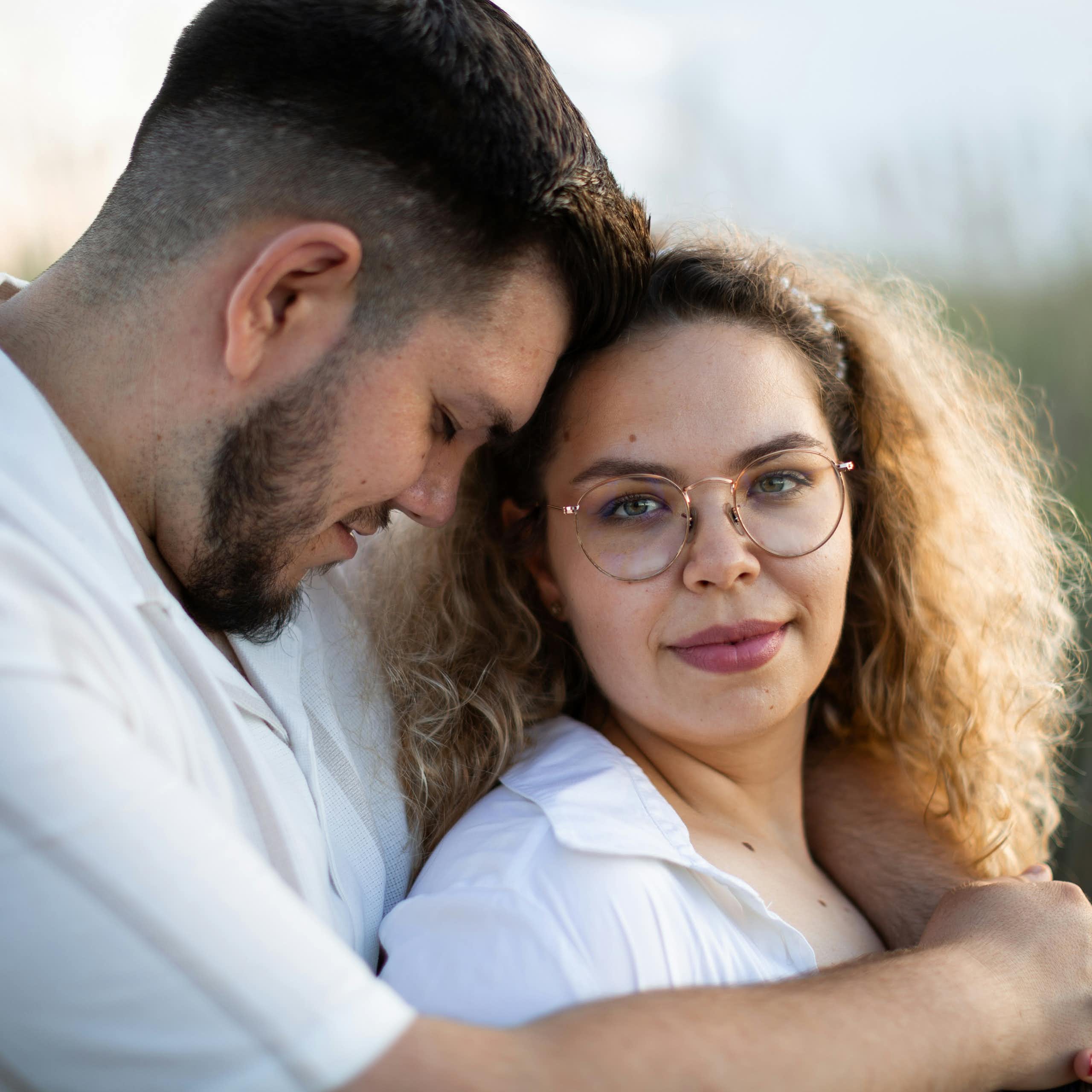 A couple hugging in and outdoors scene.
