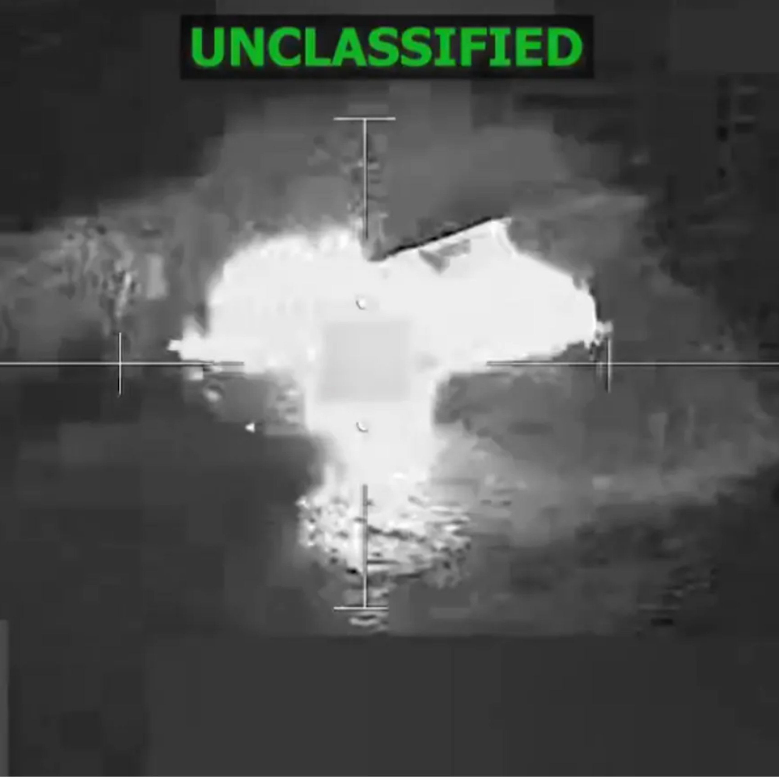 A screengrab from a video shows an aerial shot of an explosion. The word Unclassified is spelled in green at the top of the shot.