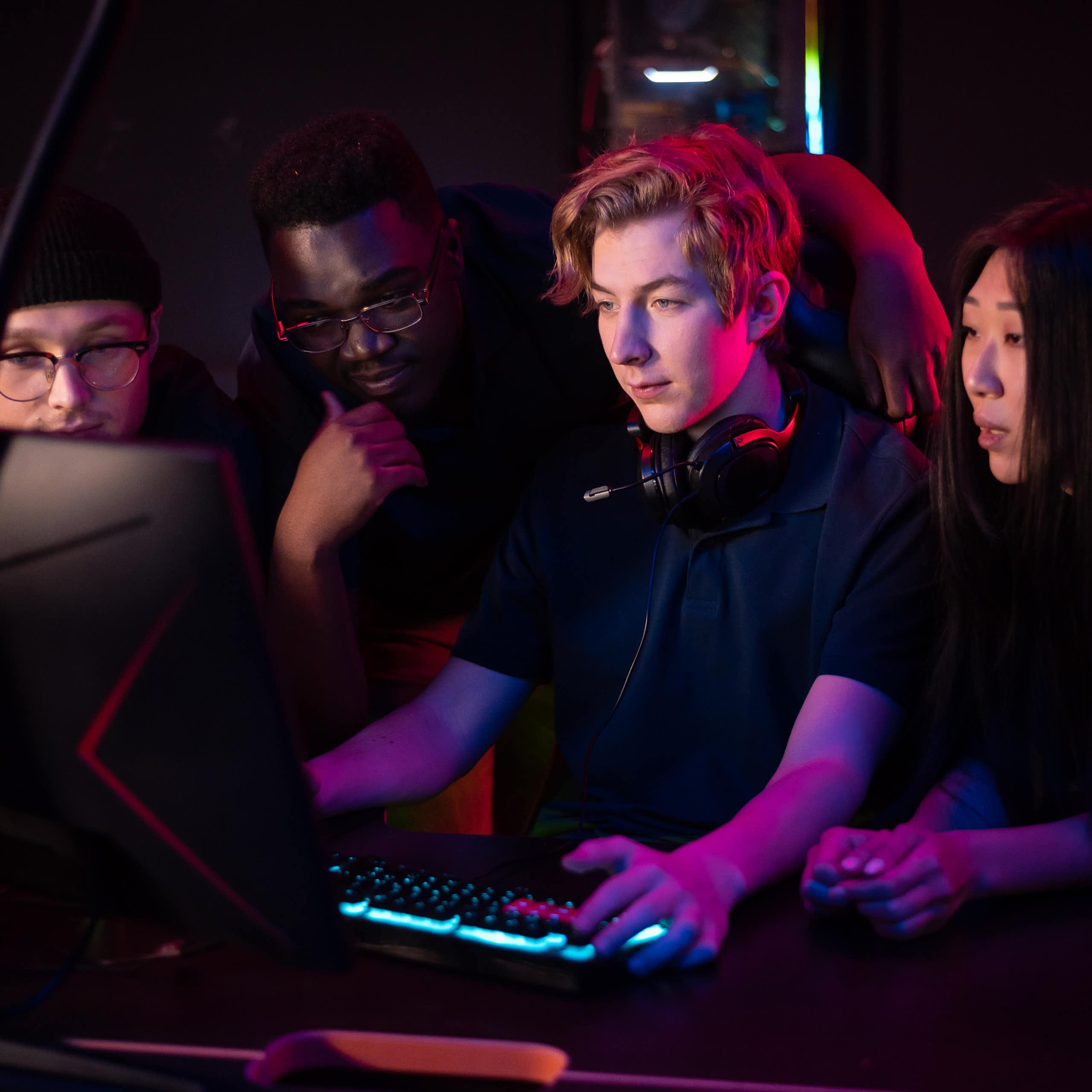 Des jeunes gens, hommes et femmes, en train de jouer devant un écran d'ordinateur.