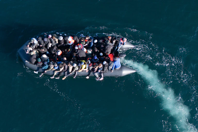 View from above of a small boat filled with people in the ocean