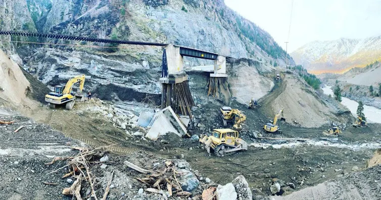 tractors and diggers clear debris following a flood