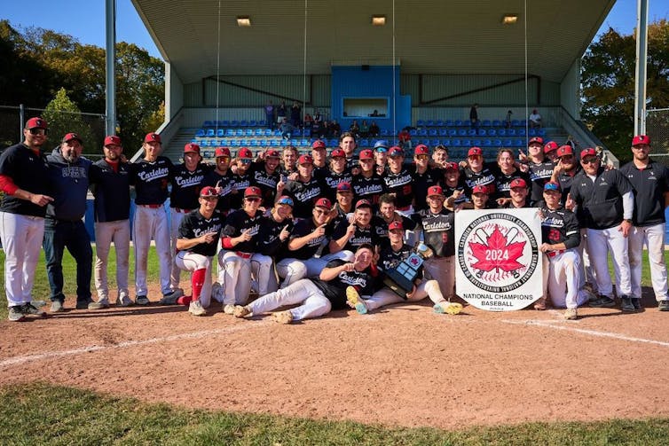 El béisbol en Canadá está prosperando, pero no en el campus 3 Un grupo de jugadores de béisbol se alinearon con un colgante que dice