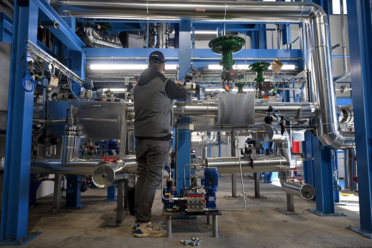 What are small modular reactors, a brand new form of nuclear energy plant sought to feed AI’s power call for? 2 A person stands in front of a complicated piece of machinery.