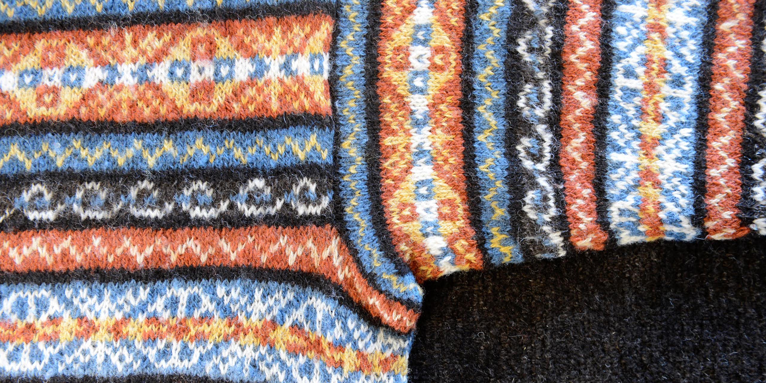 A knitted Fair Isle woollen jumper in a brown, blue and orange pattern