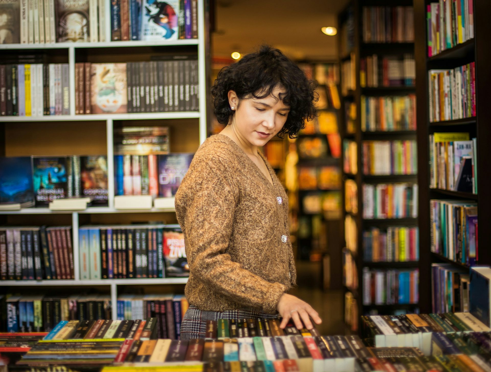 A young woman browsing a bookstore.