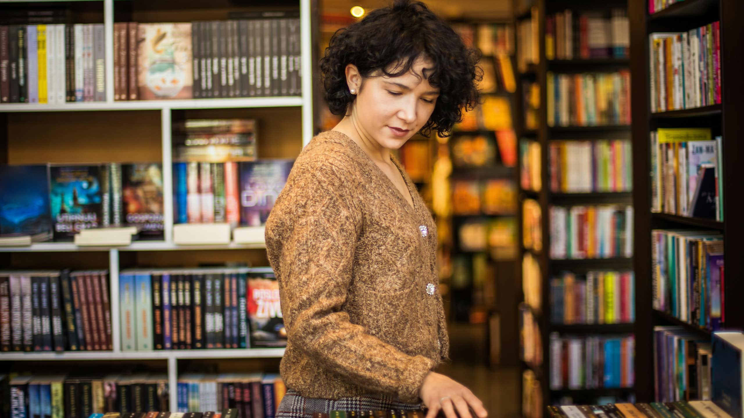 A young woman browsing a bookstore.