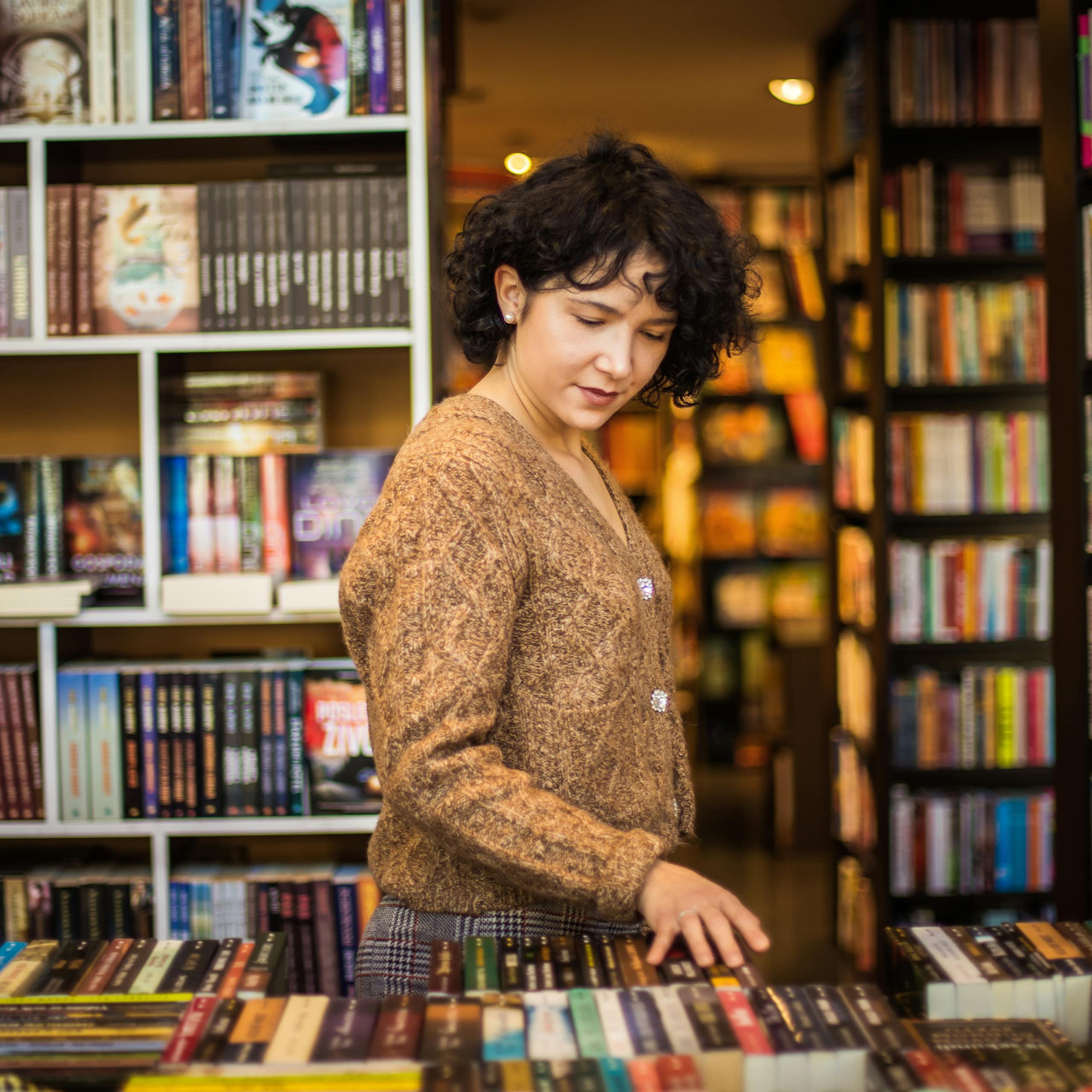 A young woman browsing a bookstore.