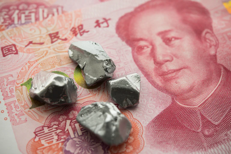 Small grey stones on a red Chinese yuan banknote