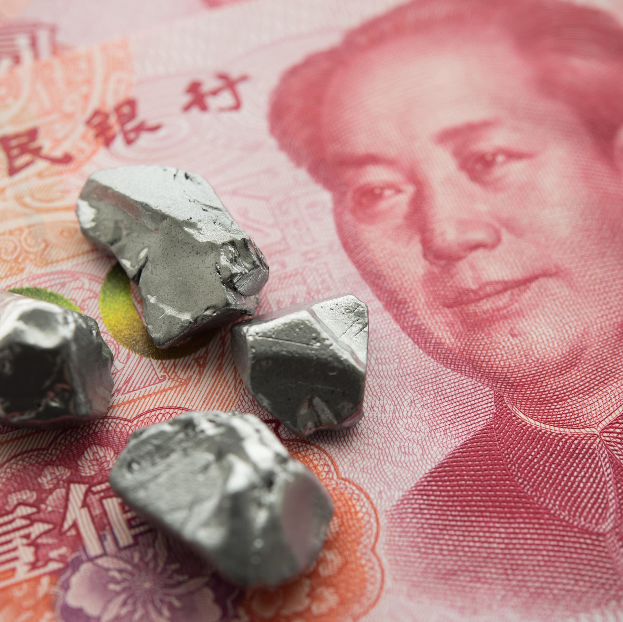 Small grey stones on a red Chinese yuan banknote