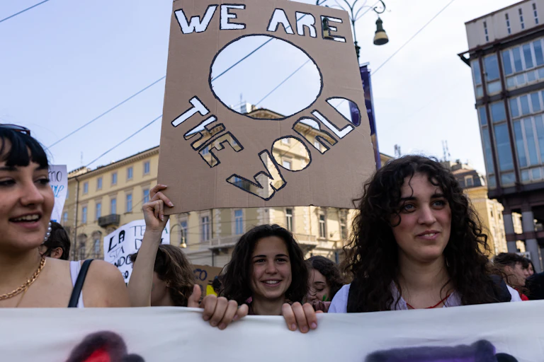 Young people at a rally, with a sign saying "We are the world"
